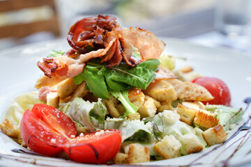 Cesar salad in white plate on the table at restaurant in day