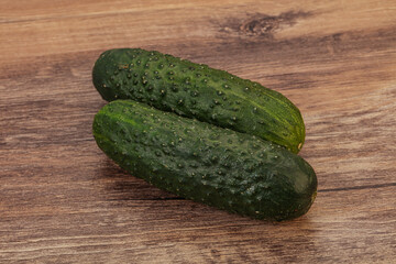 Green fresh cucumbers over background