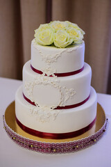 Obraz na płótnie Canvas White wedding cake with roses on table