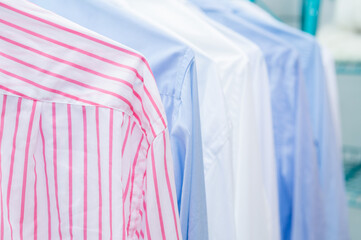 Clean shirts hung on hangers. Different colors