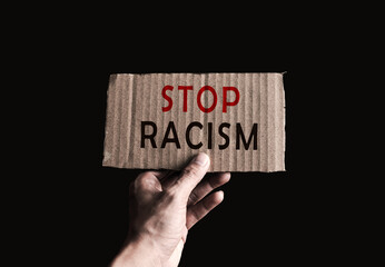 hand holding crate paper with racism word, racism concept , global news concept , discrimination concept