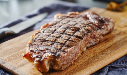 Fototapeta grilled new york strip steak resting on wooden cutting board obraz