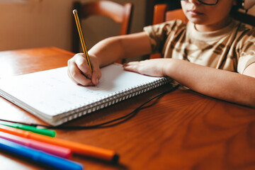 Fototapeta na wymiar Detail shot of boy doing homework at home.