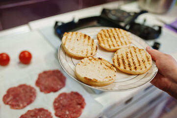 Сooking burgers in the kitchen at home during quarantine time.