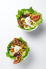 Fresh lettuce salad with tomatoes, red onion, corn, carrots, cucumber