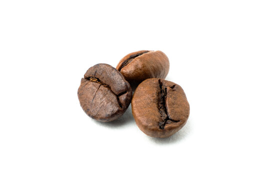 three freshly roasted coffee beans isolated on a white background