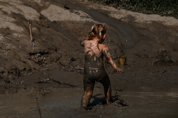 Little girl is playing in the mud