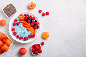 Chia seeds pudding bowl with apricot, raspberry on concrete background. Mousse with chia seeds, berries and fruits for healthy breakfast, top view