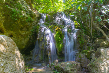 Fototapeta premium Beautiful waterfall in the forest. Long exposure shot. Wild nature, national park, hiking touristic path.