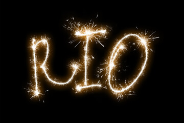 The inscription Rio on a black background with sparklers using a simulated long exposure.