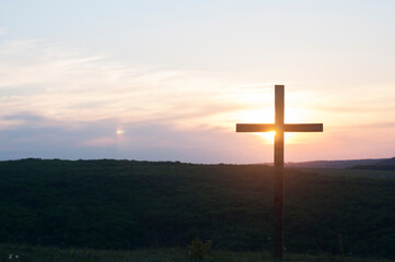 Crucifixion at Calvary. Wooden cross against the sky. Silhouette of a cross Sunset.