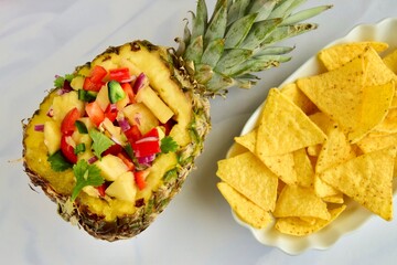 Homemade Fresh Pineapple Salsa in Pineapple Bowl. Served with Tortilla chips