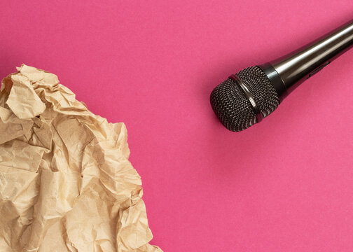 ASMR concept. Specific auditory irritants. Wrinkled paper lie in front of the microphone. Top view, flat lay.