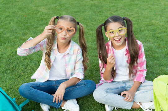 Enjoying playtime. back to school. literature for girls. do homework together. find something interesting in book. making notes. spend free time with party glasses. small kid friends relax on grass