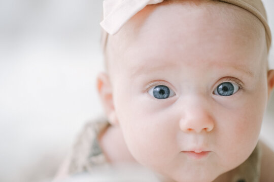 Closeup of blue eyed baby girl looking at camera