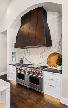 Beautiful stainless steel oven and large range hood in new luxury home