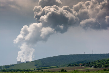 Fototapeta na wymiar Clouds of steam coming out from cooling towers of nuclear power plant.