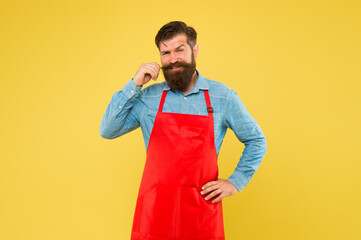 Preparation and culinary. mature bartender. his new business. guy in shop assistant uniform. smiling man with red apron on yellow background. Confident expression. Handsome male barista is working