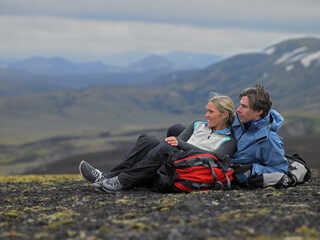 Hiking couple relaxing on mountainside in Iceland