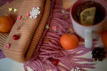 Photo for the New Year card. New Year's composition. View from above. Warm knitted scarf in purple. Tangerines lie on a scarf. Christmas composition with tangerines and a scarf.
