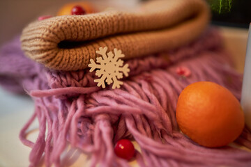 Photo for the New Year card. New Year's composition. View from above. Warm knitted scarf in purple. Tangerines lie on a scarf. Christmas composition with tangerines and a scarf.