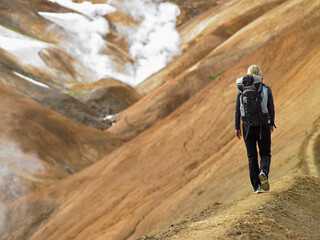 young woman hiking along ridge in the Icelandic highlands