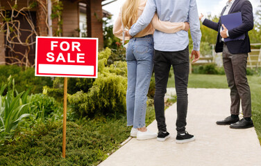Cropped view of millennial couple and real estate agent near house for sale, outdoors