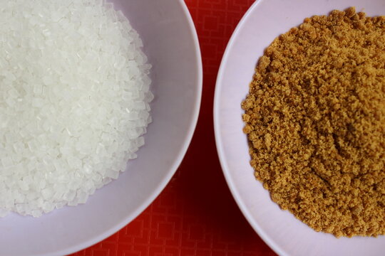 Close up of unhealthy refined sugar and healthy jaggery powder