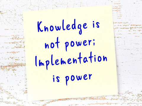 Yellow sticky note on wooden wall with wise quote