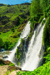 Fototapeta na wymiar High full-flowing picturesque waterfall of Armenia Shaki