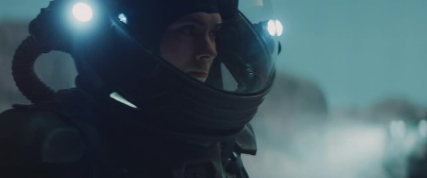 Caucasian female astronaunt checking hud on her suit while exploring planet surface, Mars colonization concept