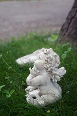 closeup of little stoned angel in the grass in a cemetery