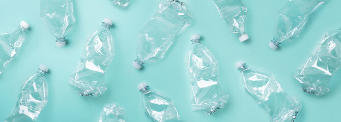 Empty rumpled used plastic bottle on blue background. Top view, copy space. Pollution,...