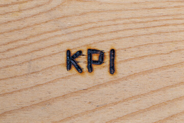 an abbreviation KPI - key performance indicator - burned by hand with electric wood burner on...