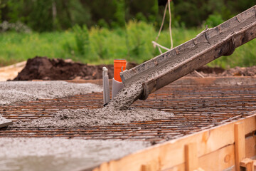 Lay of the cement or concrete into the foundation formwork from concrete mixer