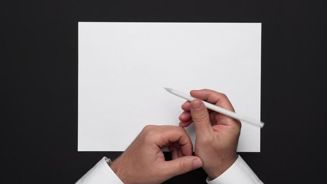 top view of a blank sheet of paper and a businessman's hands on a black table, white shirt and wrist watch