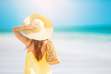 Young beautiful woman having fun on tropical seashore. Happy girl background the blue sky and turquoise water in the sea