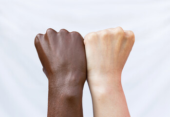 Fists of the hands of a black and white man. Protest against racial discrimination. The concept of ending racism - obrazy, fototapety, plakaty