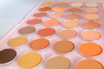 close up and top view of an eye shadow palette of many colors