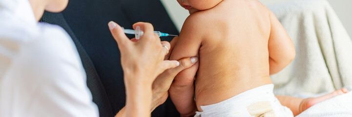 Obraz na płótnie Canvas Pediatric doctor vaccinating a baby