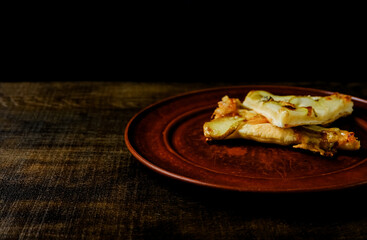 Homemade pizza on a wooden table. On a dark background. Place for text