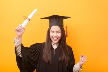 Portrait of happy Beautiful woman in graduation gown is holding education certificate on yellow...