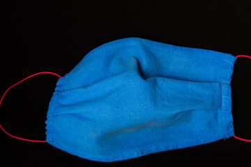 blue fabric face masks on a black background to prevent covid 19