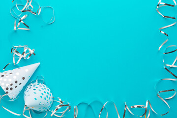 Decoration party. Caps and silver serpentine on a blue paper background. Holiday background. Copy space