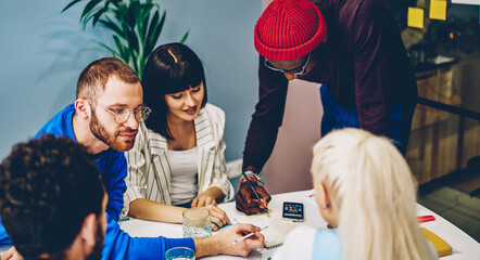 Multiracial crew of skilled clever students cooperating on project and learning together.