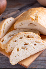 Freshly baked ciabatta bread on wooden cutting board. Ciabatta with ears on the table