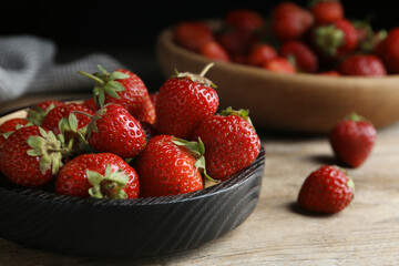 Delicious ripe strawberries on wooden plate, closeup