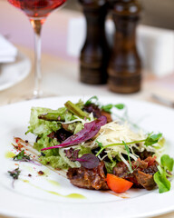 big tasty salad lies on white plate on isolate