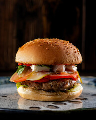 Delicious golden burger lies on a beautiful ceramic plate.