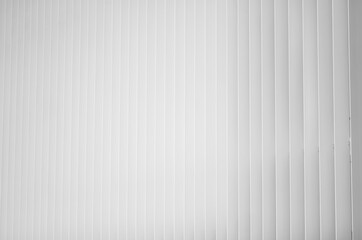 Fototapeta premium shades of white caused by light and perspective, on a building with a white railing, composed of vertical linear elements.
